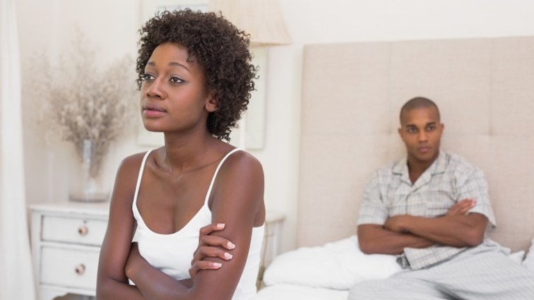 Unhappy couple not speaking to each other on bed at home in the