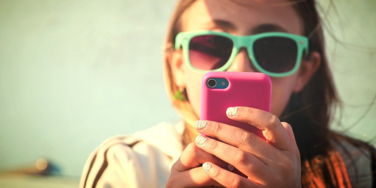 Young girl texting at the beach